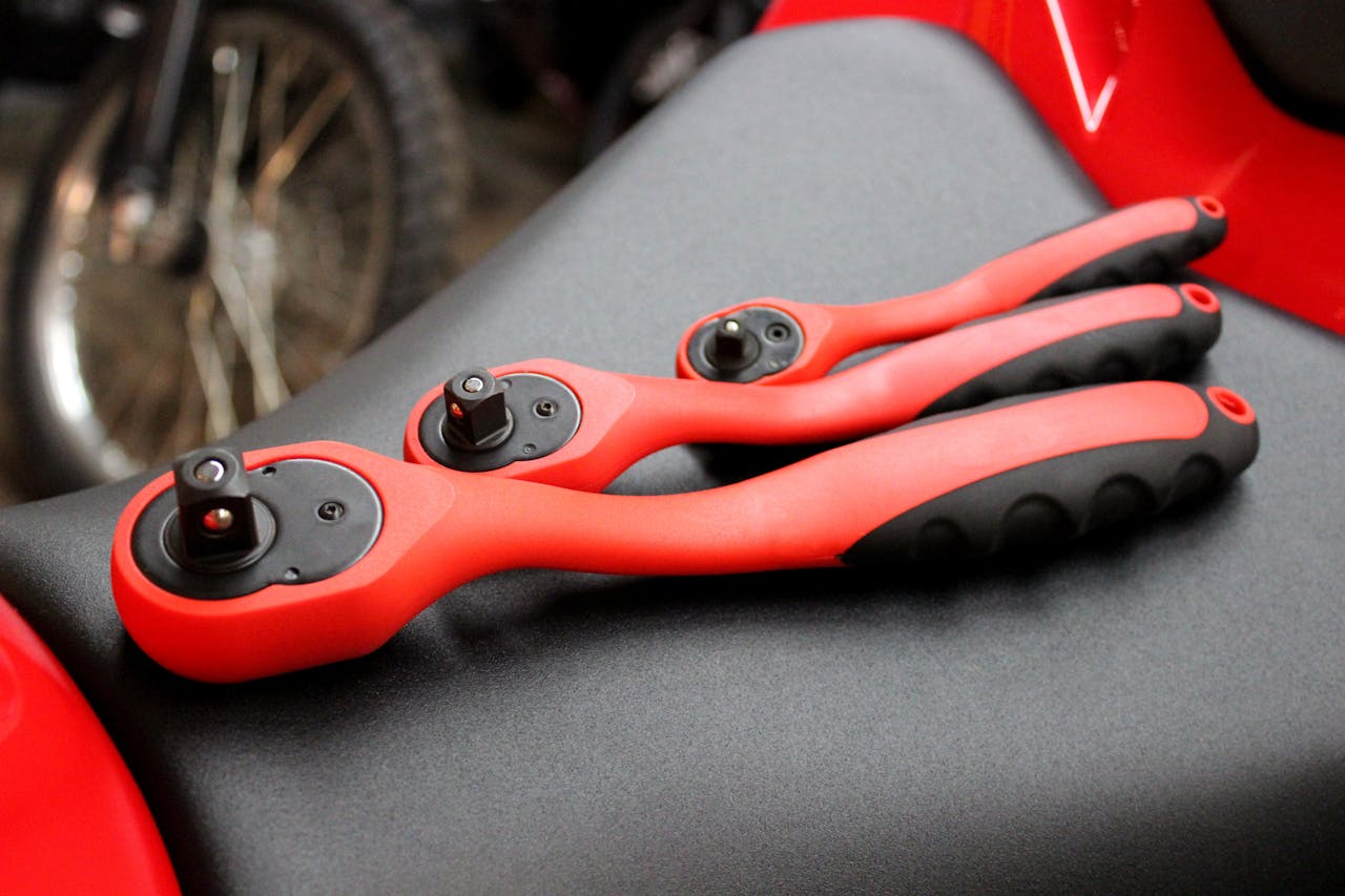 Mastering the First Impression: Your intriguing post title goes here Close-up of red and black socket wrenches on a motorcycle seat.